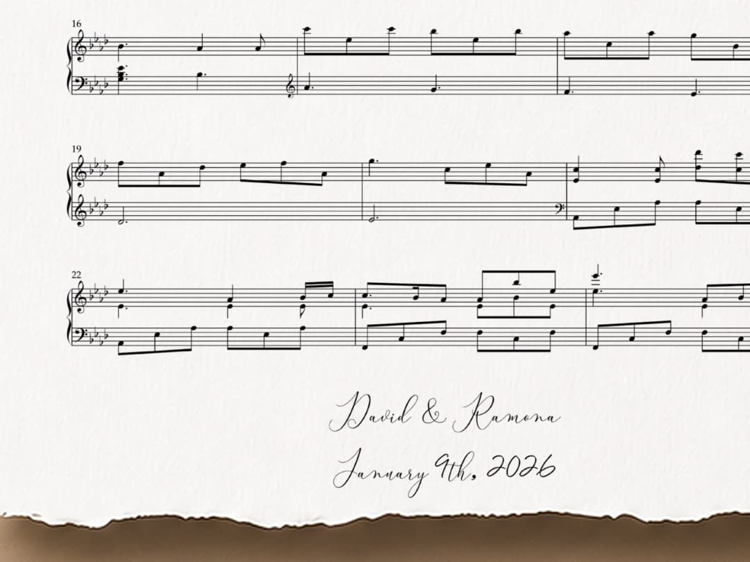 A close-up of the bottom of a Soneveil print, showing the couple’s names and their date hand-lettered in script beneath the final bars of music, with the torn deckle edge of the cotton paper running along the bottom.